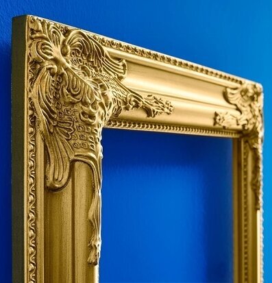Bild av förgylld ram i barockstil med blå bakgrund