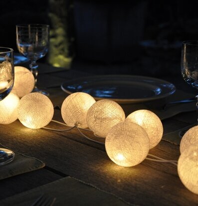 Foto av vacker dukning med ljusslingor i skymningen