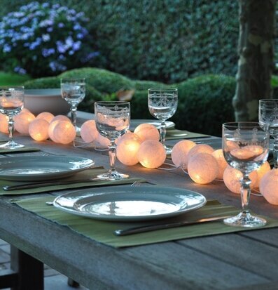 Foto av stämningsfullt dukat bord med ljusslinga