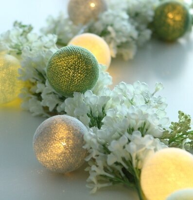 Bild av ljusslinga med färgglada kulor och blommor