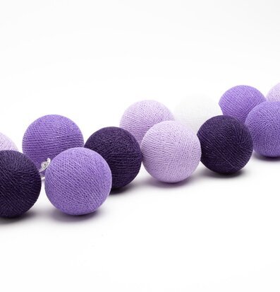 Bild av ljusslinga med lila och vita dekorativa bollar