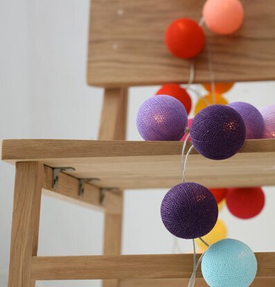 Bild av dekorativ ljusslinga på trästol i färger