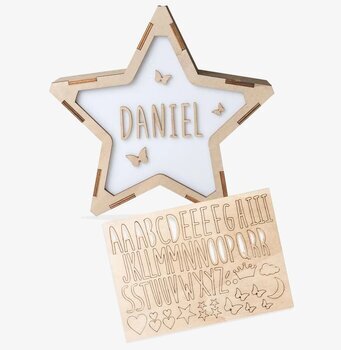 Bild av stjärnformad bokstavslampa med trädetaljer