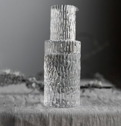 Bild av stilren karaff i klart glas med vågig textur