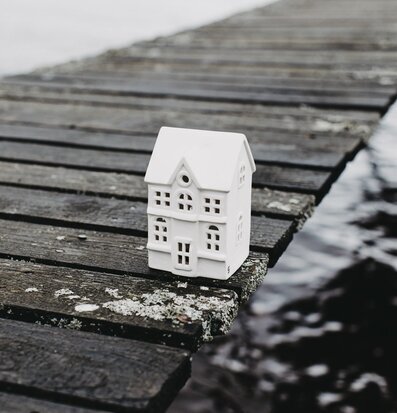 Bild av keramikljusstake på träbrygga vid vattnet