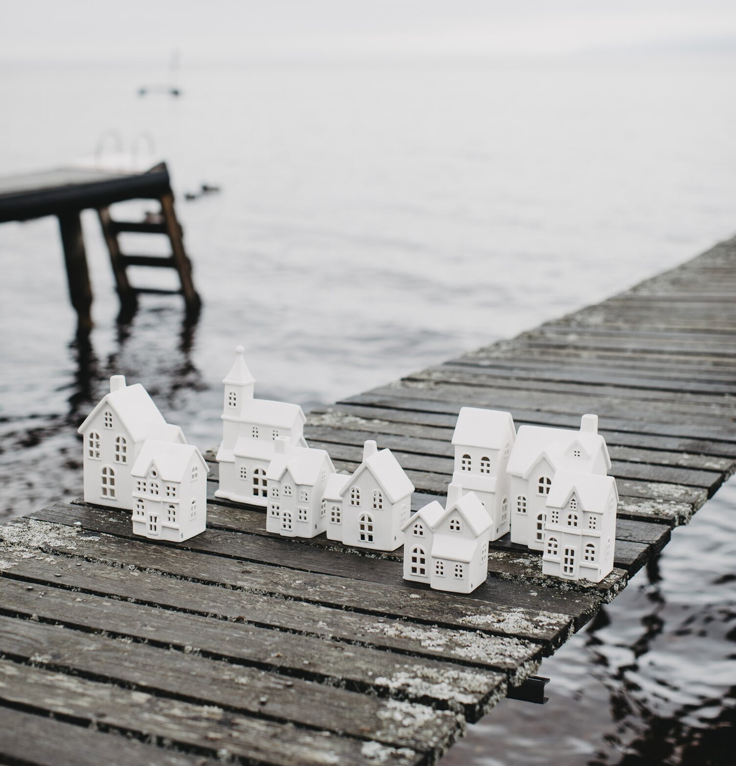 Ljusstake Hus Byn 1 från Storefactory på träbrygga vid vatten