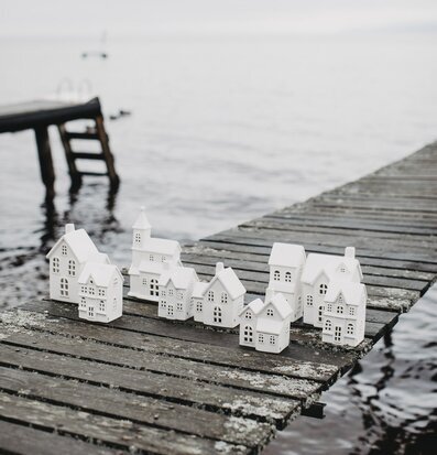 Bild av dekorativa ljusstakar på träbrygga vid sjö