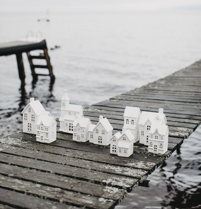 Bild av keramikljusstakar formade som hus vid vatten