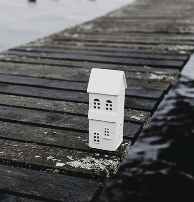 Bild av vit ljusstake på gammal brygga vid vatten