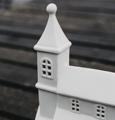 Foto av elegant vit keramisk ljusstake i husform