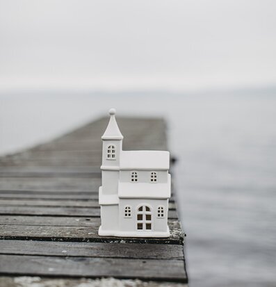 Bild av vit ljusstake på brygga vid lugnt vatten