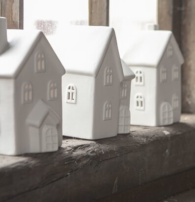 Foto av stilrena keramikljusstakar på fönsterbräda