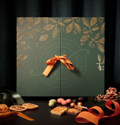 Foto av elegant förpackning med choklad och dekorationer