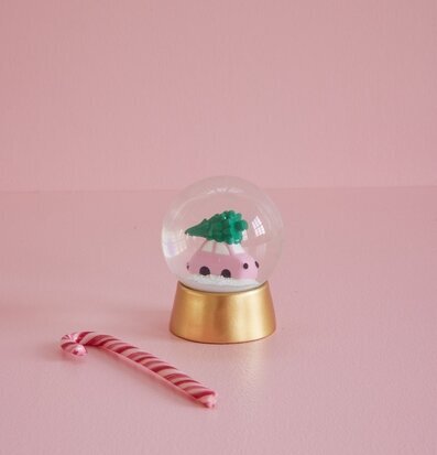 Bild av snöglob med bil och julgran i rosa miljö