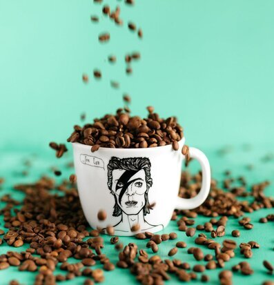 Bild av modern mugg med konstmotiv och kaffebönor