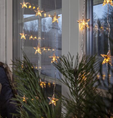 Foto av ljusgardin med stjärnor och vinterlandskap