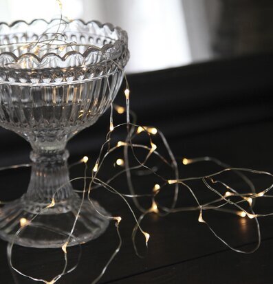 Bild av elegant glasskål med ljusslinga i stämningsljus