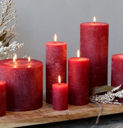 Bild av mörkröda rustika blockljus i varm miljö