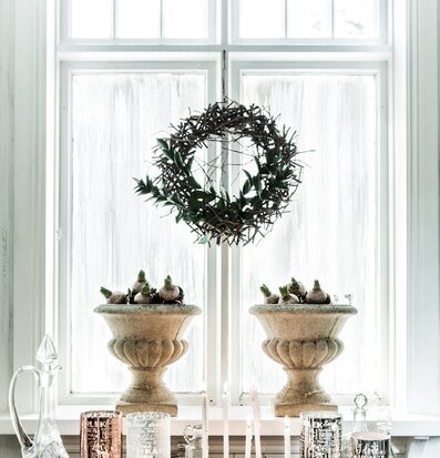 Bild av harmoniskt stilleben vid fönster med ljus och växter