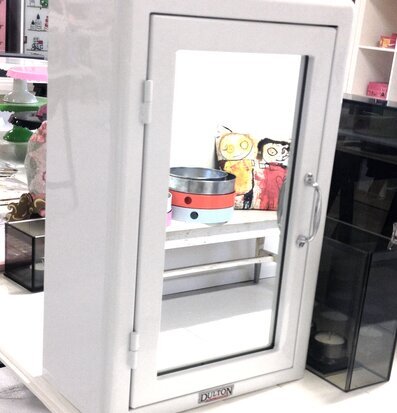 Bild av vitt medicinskåp med glasdörr och kromhandtag