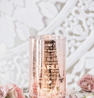 Bild av elegant ljuslykta i rosé med blommig bakgrund