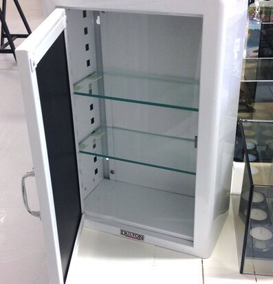 Bild av vitt skåp med glashyllor och robust handtag