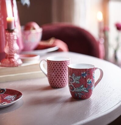 Bild av charmig dukning med blommiga och prickiga muggar