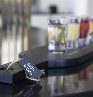 Bild av stilren träbricka med eleganta shotglas