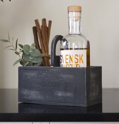 Bild av stilren grå trälåda med glögg och dekorationer