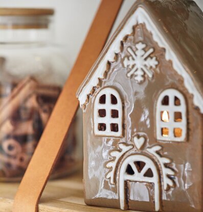 Foto av ljuslykta som pepparkakshus med snöflinga