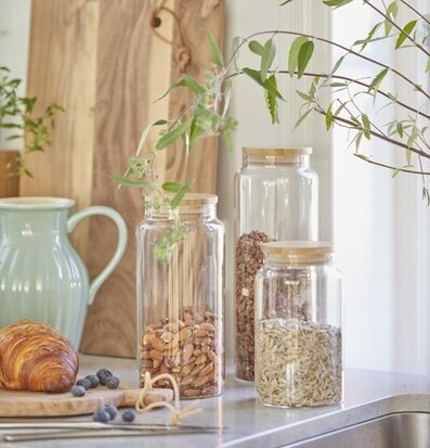 Foto av hemtrevligt kök med glasburkar och skärbrädor