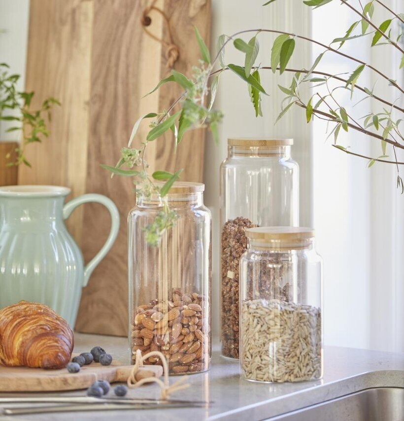 Foto av hemtrevligt kök med glasburkar och skärbrädor