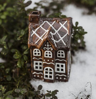 Bild av charmigt pepparkakshus i vintrigt landskap