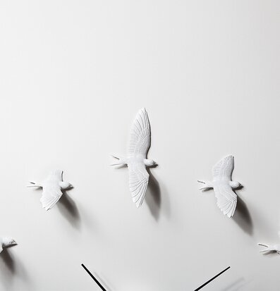 Bild av konstnärlig väggklocka med svalor i rörelse