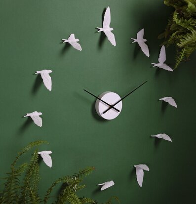 Bild av modern väggklocka med flygande svalor