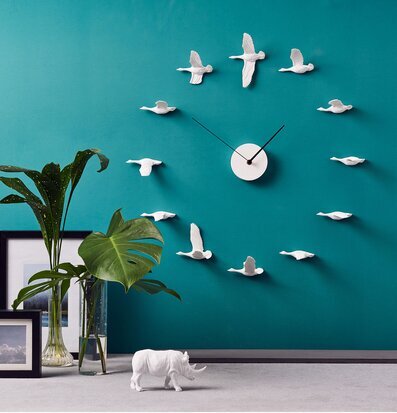 Bild av kreativ installation med väggklocka och fåglar