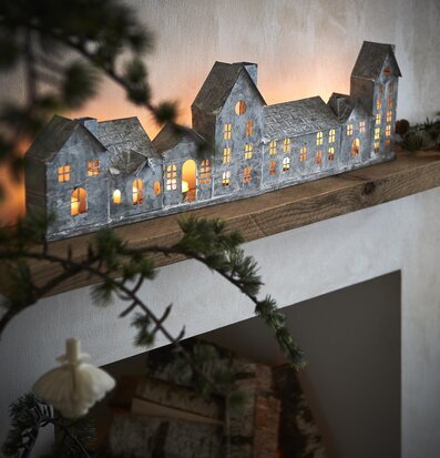 Bild av ljuslykta på rustik hylla med naturmotiv