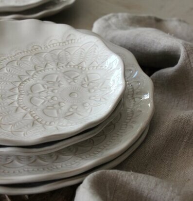 Bild av eleganta vita assietter med reliefmönster