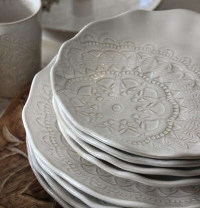 Bild av eleganta vita assietter med intrikata mönster