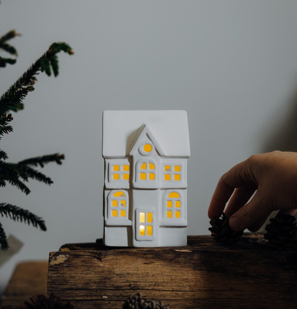 Ljusstake Hus Byn 1 från Storefactory på träyta med kottar