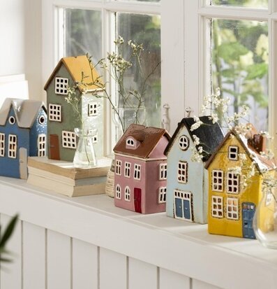 Bild av charmiga miniatyrhus på en fönsterkarm