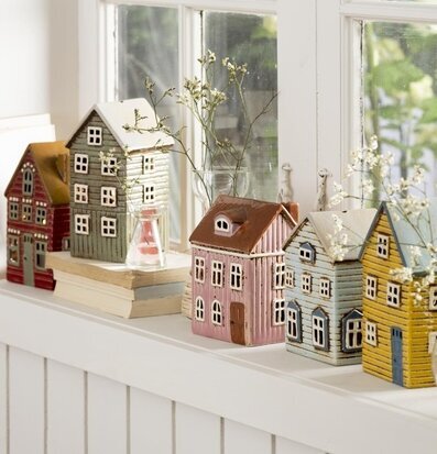 Bild av charmiga husformade ljuslyktor i fönster