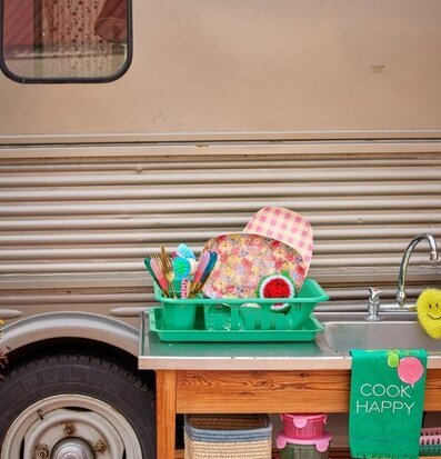 Bild av färgglatt utekök med diskställ och redskap