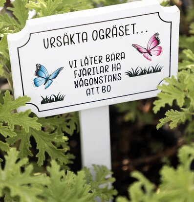 Bild av trädgårdsskylt med fjärilar och gröna blad