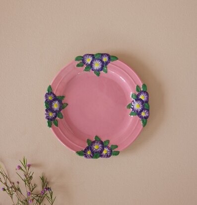 Foto av keramikassiett med blommor i rosa och lila