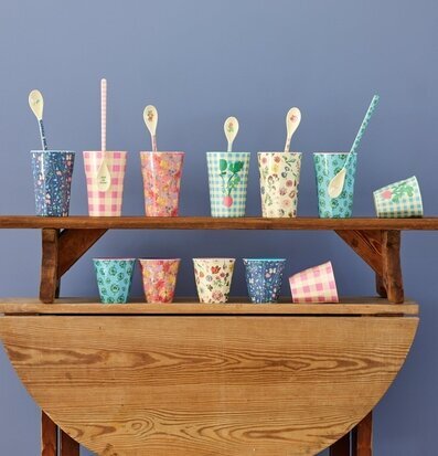 Bild av färgglada melaminmuggar på rustikt träbord