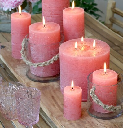 Bild av rustika hallonfärgade blockljus i trämiljö