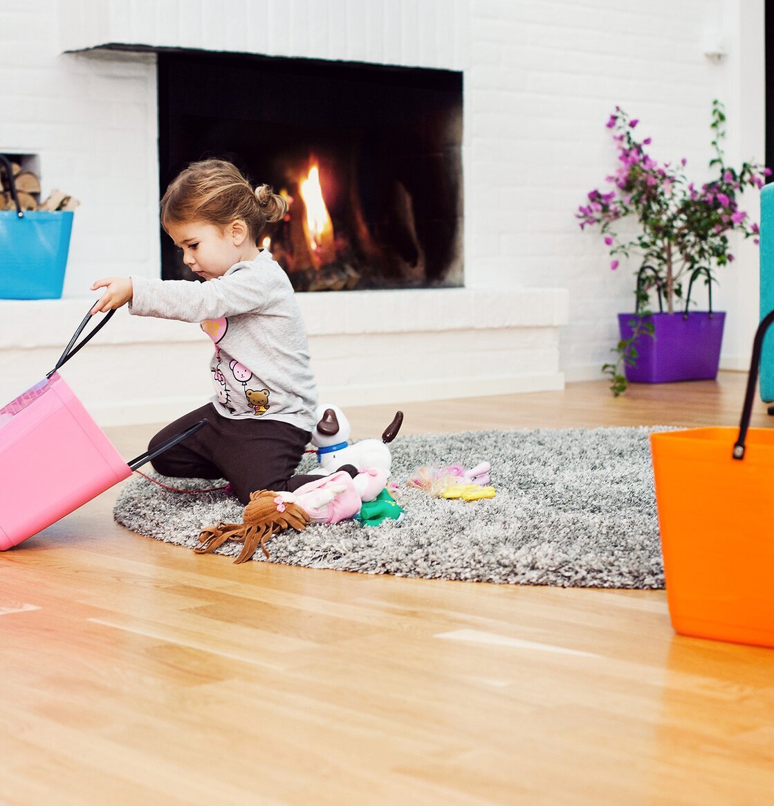 Bild av hemtrevlig scen med färgglada korgar och eld