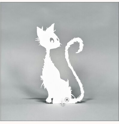 Bild av vit kattsilhuett i plåt mot grå bakgrund