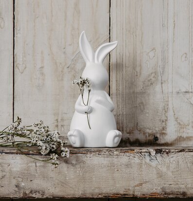 Foto av stilren kaninfigur i vit nyans med blommor